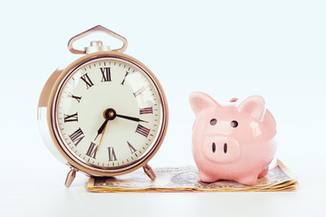 Piggy bank with clock on the heap of money.