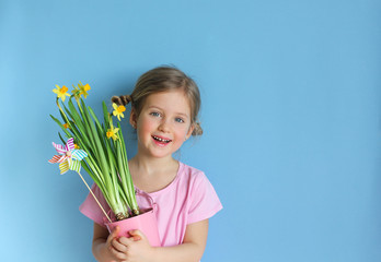 Beautiful girl holding a bouquet of flowers on a bluet background. 8 march or Womans day. Festive greeting concept. Hello spring.
