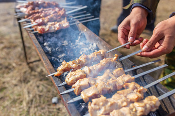 A man fries kebabs on skewers on the grill