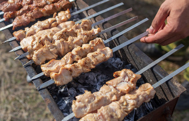 Shish kebab on skewers is fried on a brazier