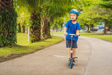 Boy riding scooters, outdoor in the park, summertime. Kids are happy playing outdoors