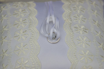Wedding ring with the white soft ribbon on the pillow