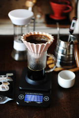 Fototapeta na wymiar Alternative manual hand coffee brewing in pink ceramic origami dripper with paper filter. Grinder. Gooseneck kettle. Electronic scale