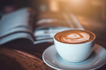 Latte art coffee on the table with magazine 