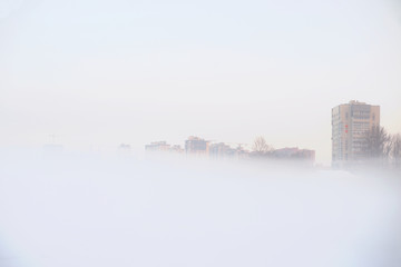 Cityscape with residential buildings on a foggy winter day.