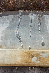 Close-up spring drops on the street in a large macro increase in the sunlight day. Soft and selective focus.