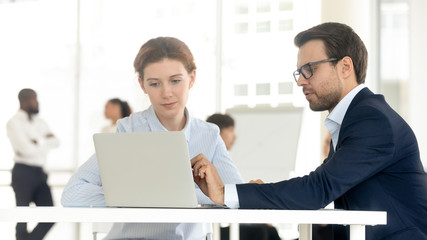 Businessman and businesswoman working together use computer in coworking office