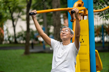 The elderly man with exercise equipment in park