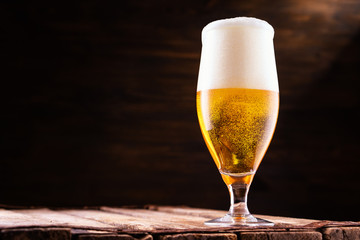 Cold beer into a glass with  foam.