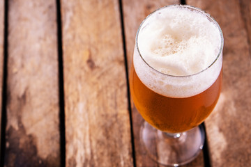 Cold beer into a glass with  foam.