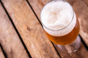 Cold beer into a glass with  foam.