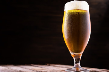 Cold beer into a glass with  foam.