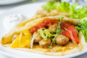 Thin delicious pancake with meat balls and pepper on white