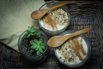 Rice pudding served in glass cups. Decorated. Close-up. Homemade dessert decorated with handmade napkins in a wicker tray.