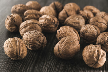 Walnuts closeup against dark wood table background. Vintage cool look