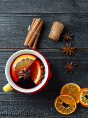 red knitted mug of mulled wine on a dark wooden table