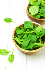 Fresh green spinach leaves on wooden bowl on white wooden rustic background Selective focus copy space. Baby young spinach leaves, Ingredient for salad, healthy food, diet. Nutrition concept.