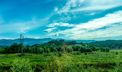 Fototapeta na wymiar Italy, Rome to Florence train, a large green field with a mountain in the background