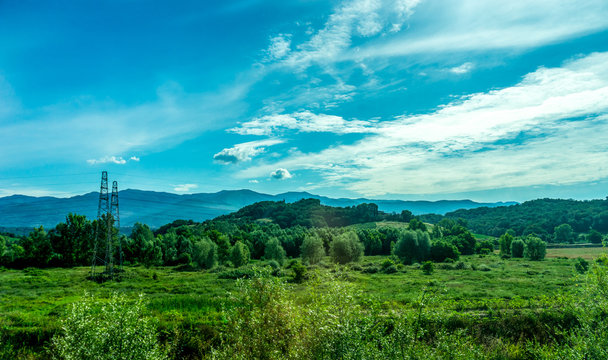 Italy, Rome to Florence train, a large green field with a mountain in the background