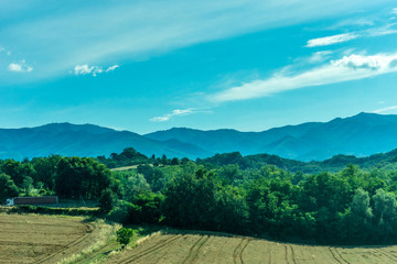Italy, Rome to Florence train, a large green field with a mountain in the background