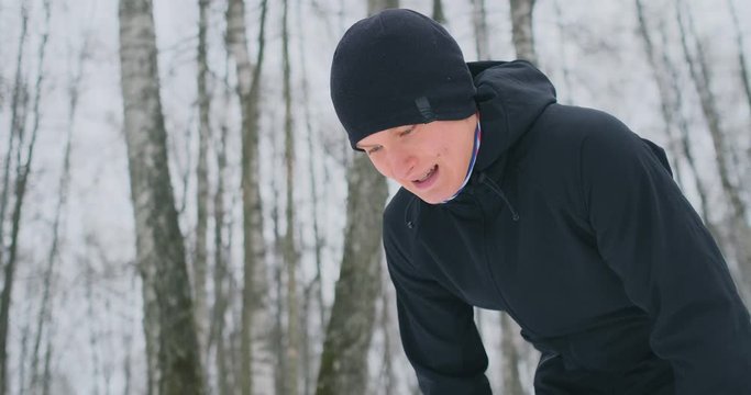 A young man on a morning jog in the winter forest was tired and stopped to rest and ran on. He recovered his strength and overcame fatigue and continued to run. Perseverance and overcoming weakness