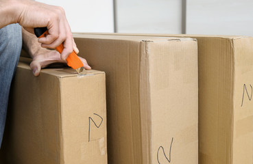 A man is unpacking the cardboard boxes.