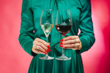 Hand and wine. Close up. Modern sommelier estimating smell of wine in wineglass while relaxing. Forever young.