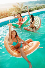 Fototapeta na wymiar Three girls relaxing and having fun in the pool 