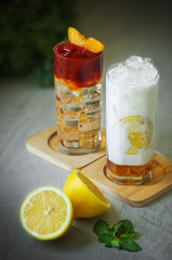 Honey milk and peach tea on white wood background.