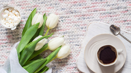 Bouquet of white tulips and cup of coffee