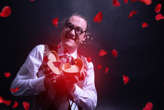Crazy happy guy holding red heart gift box - present valentines day - love - with flying petals - roses