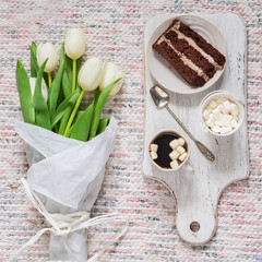 Bouquet of white tulips, coffee and chocolate cake