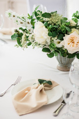 wedding table decorated by plates, knives and forks