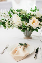 wedding table decorated by plates, knives and forks