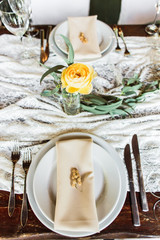 wedding table decorated by plates, knives and forks