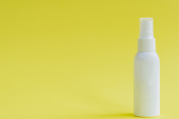 White packaging spray cosmetic plastic bottle on yellow background. Mockup for hair or body care products