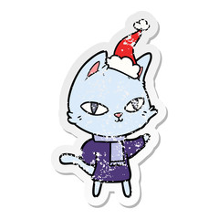 distressed sticker cartoon of a cat staring wearing santa hat