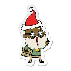 sticker cartoon of a joyful man with beard and parcel under arm wearing santa hat