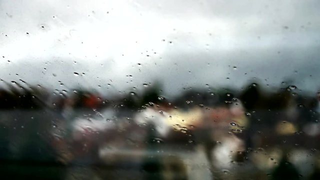 Timelapse of rainstorm hitting window with slite flex of the window from the hard wind blured town in background