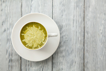 cup of hot matcha green tea latte on wood background
