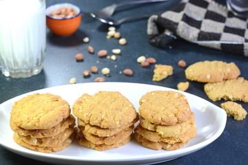Peanut cookies and milk with cookie crumbs and peanuts on the background