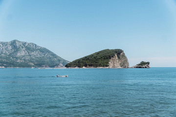 Seascape of the Adriatic Sea. The sea with mountains and mountains in the background. Boat sailing on the sea. Italy, Montenegro, Adriatic tourism