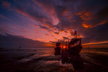 The background of the fishing boats is docked at the beach, with colorful skies in the morning, the natural beauty and the coexistence of fishermen on the waterfront