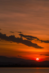 Close nature view Of the colorful sky (golden yellow) of the sun in the morning by the lake, behind the mountain, a beautiful journey