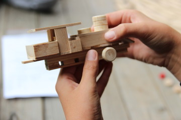Fototapeta premium Child's hand, fold and stick a wooden toy