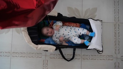 Funny action with little kid in the little bed with ballon in shape of heart.