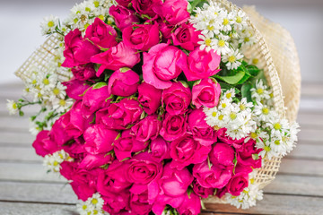 The view of the pink rose bouquet close-up,arranged on wooden table,be used to display,to various festivals(Valentine,wedding,New Year's party,birthday party)or to decorate in Restaurant,coffee shop