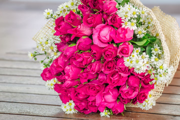 The view of the pink rose bouquet close-up,arranged on wooden table,be used to display,to various festivals(Valentine,wedding,New Year's party,birthday party)or to decorate in Restaurant,coffee shop