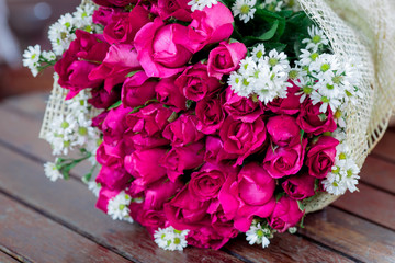 The view of the pink rose bouquet close-up,arranged on wooden table,be used to display,to various festivals(Valentine,wedding,New Year's party,birthday party)or to decorate in Restaurant,coffee shop