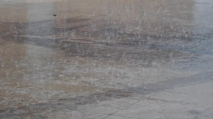 Heavy rain during a winter day falling on the street